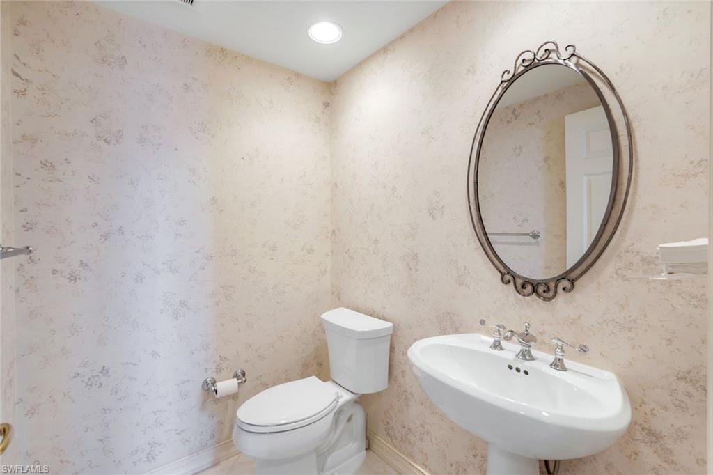 425 Dockside Drive, Unit 604 Naples, FL 34110 - Photo 24 of 34 a bathroom with a toilet a sink and a mirror