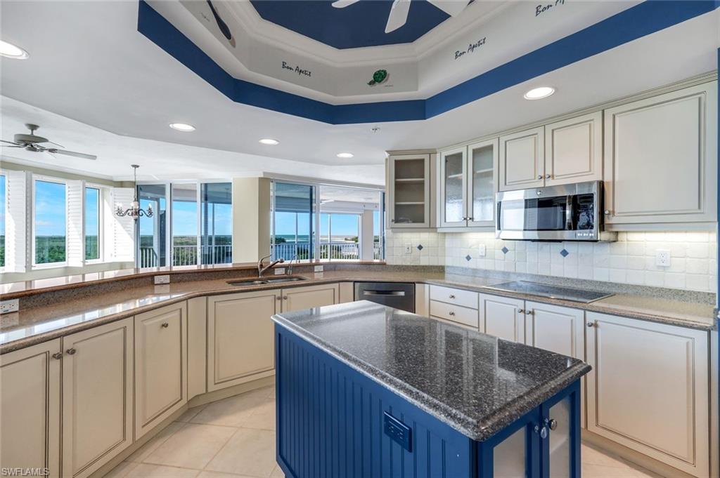 425 Dockside Drive, Unit 604 Naples, FL 34110 - Photo 6 of 34 a kitchen with granite countertop a sink and dishwasher a stove top oven with wooden floor