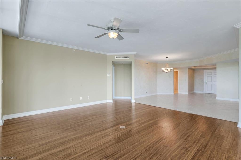 425 Dockside Drive, Unit 604 Naples, FL 34110 - Photo 10 of 34 a view of an empty room with wooden floor and a ceiling fan