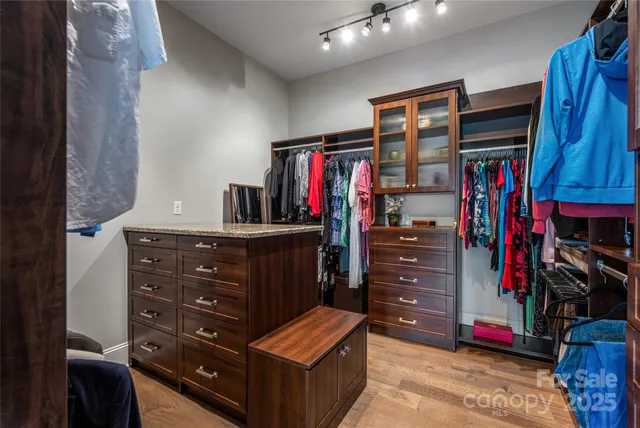 a view of walk in closet with clothes