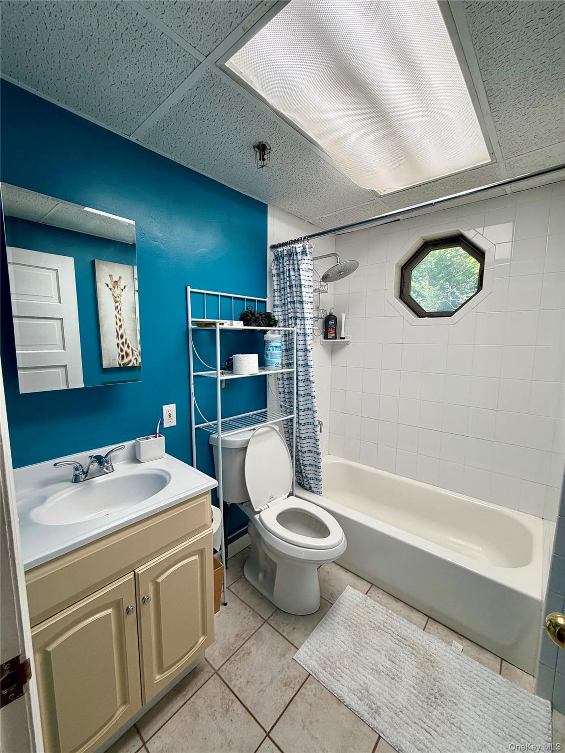 149 Fort Salonga Road Northport, NY 11768 - Photo 7 of 23 Full bathroom featuring a single vanity, standard bathtub with shower, and an octagonal window and skylight