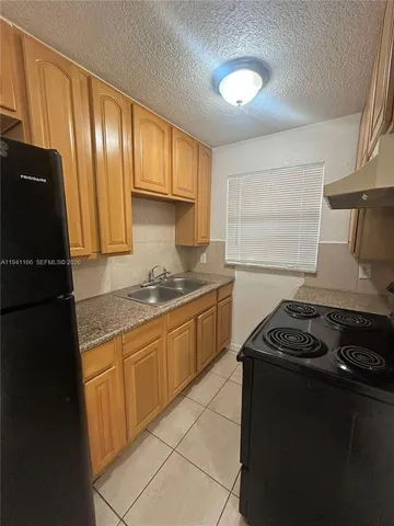 a kitchen with granite countertop stainless steel appliances and wooden cabinets