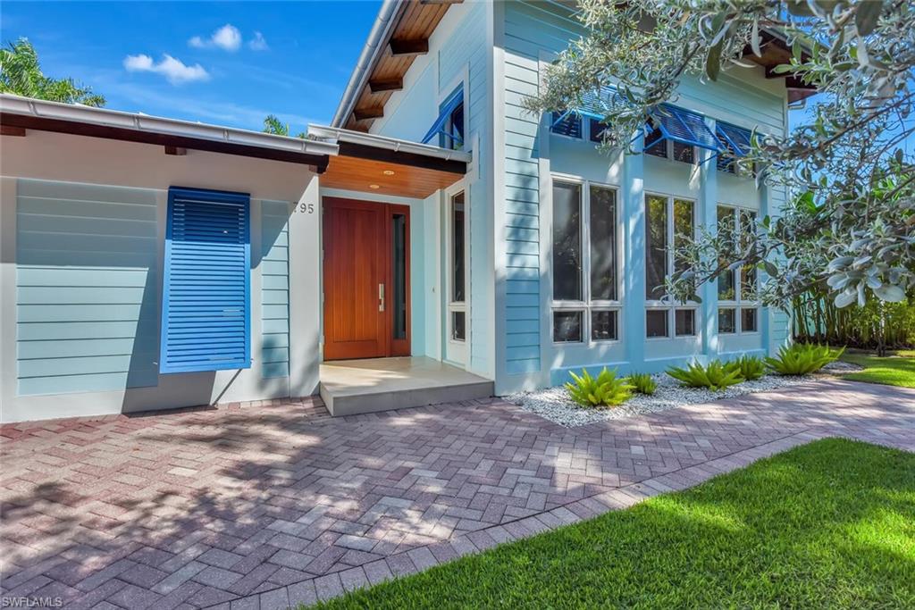 795 18th Avenue South Naples, FL 34102 - Photo 3 of 48 a view of yellow house with a yard and plants