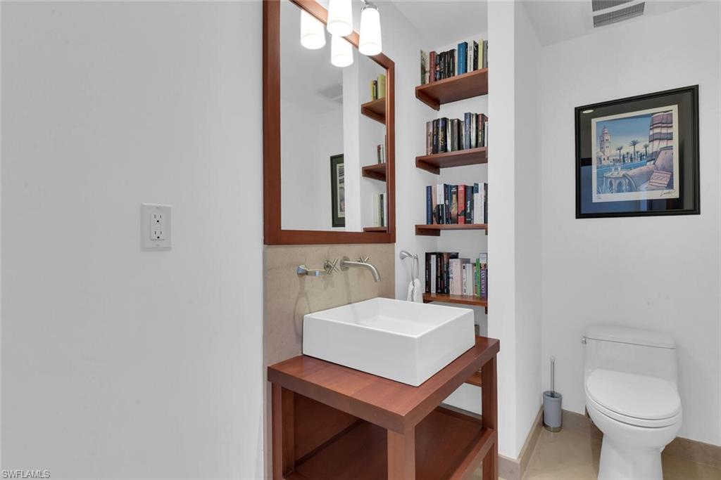 795 18th Avenue South Naples, FL 34102 - Photo 35 of 48 a bathroom with a toilet a sink and a mirror