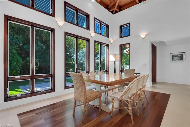 a dining room with furniture large windows and wooden floor
