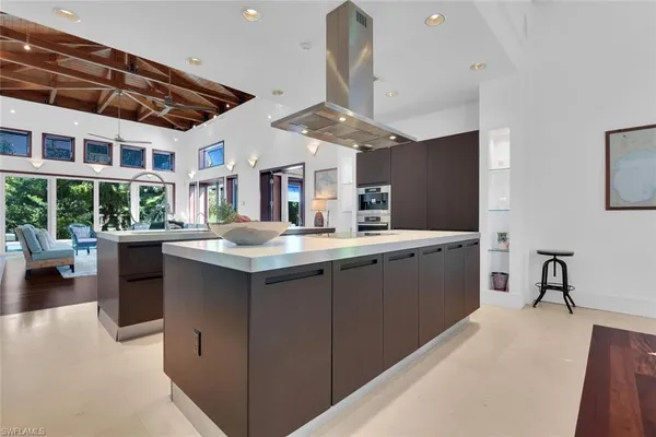 a kitchen with stainless steel appliances kitchen island granite countertop a sink counter space and a stove top oven