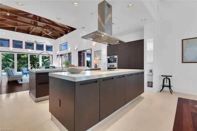 a kitchen with stainless steel appliances kitchen island granite countertop a sink counter space and a stove top oven