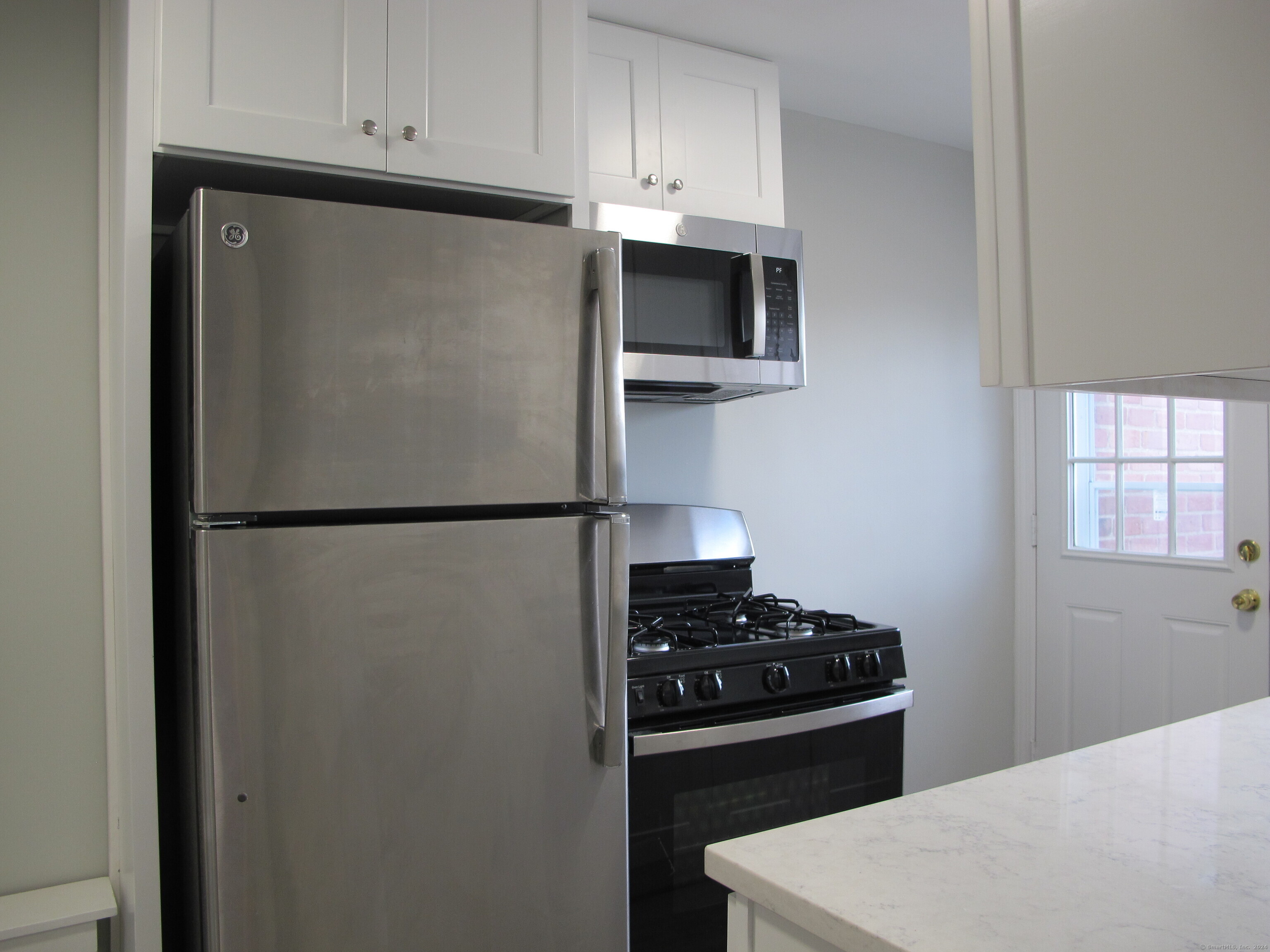 175 Seaton Road, Unit 3 Stamford, CT 06902 - Photo 4 of 14 a kitchen with a refrigerator and a stove top oven