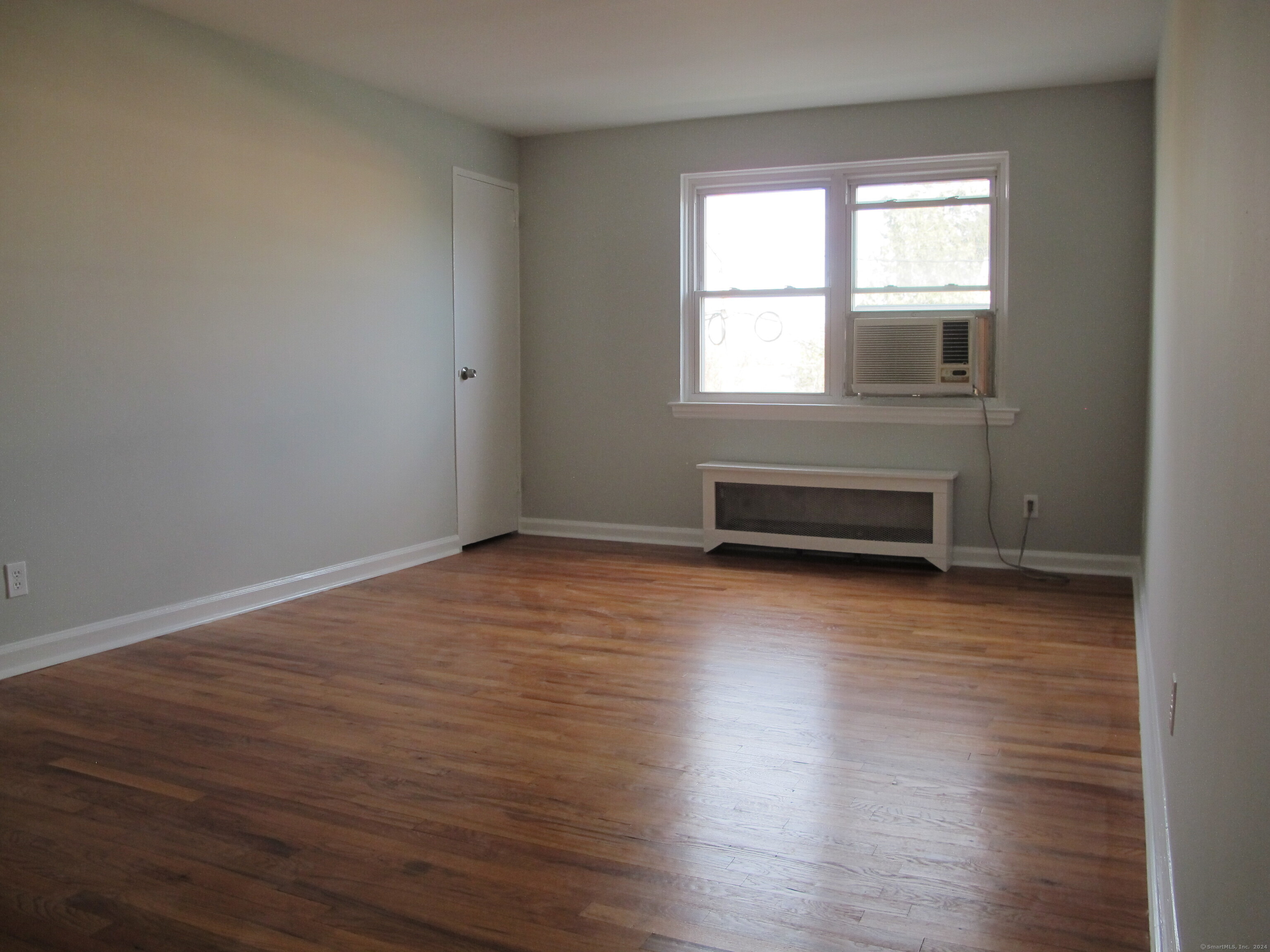 175 Seaton Road, Unit 3 Stamford, CT 06902 - Photo 6 of 14 a view of a room with wooden floor and windows