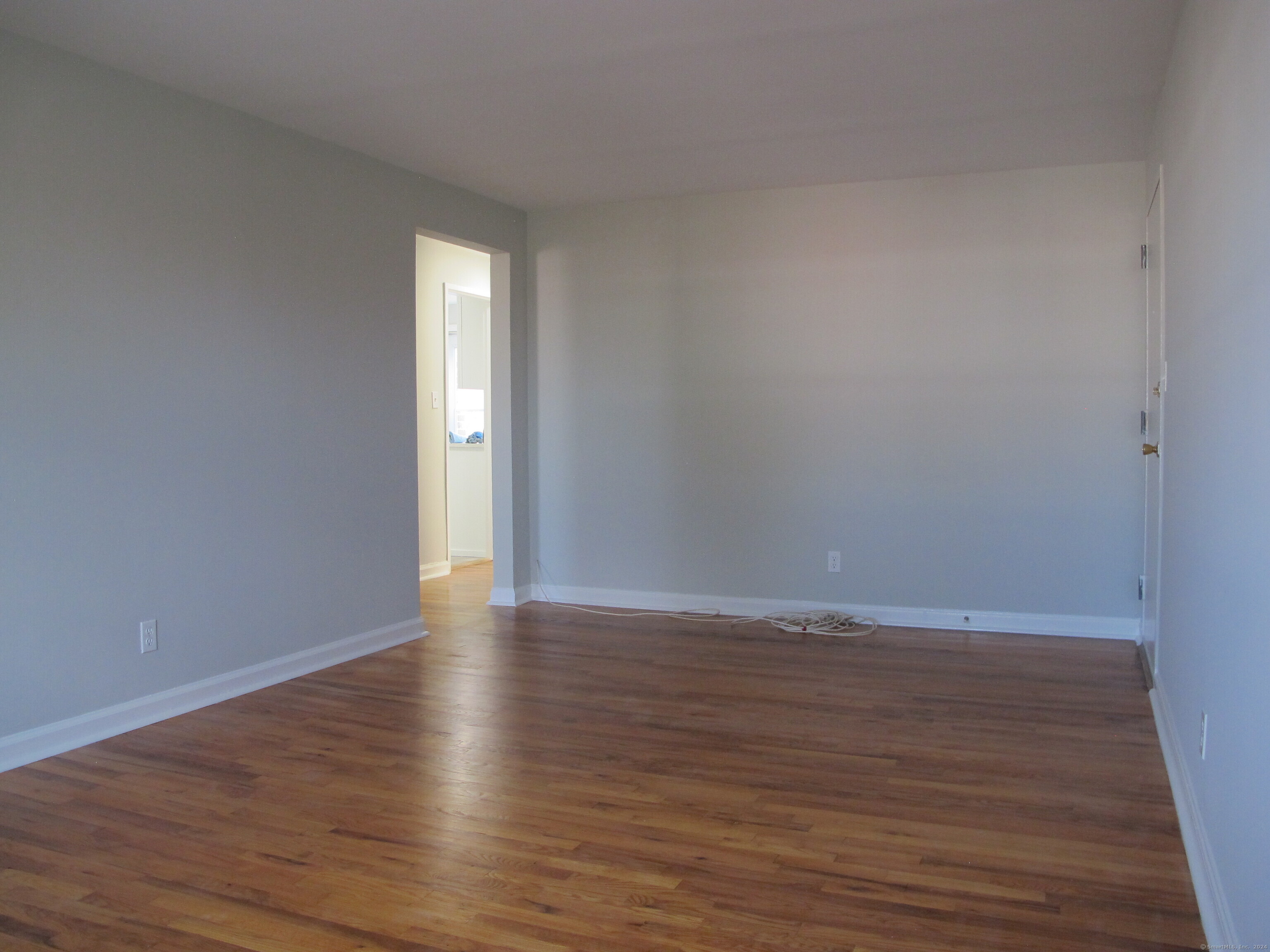 175 Seaton Road, Unit 3 Stamford, CT 06902 - Photo 7 of 14 a view of an empty room with wooden floor and window