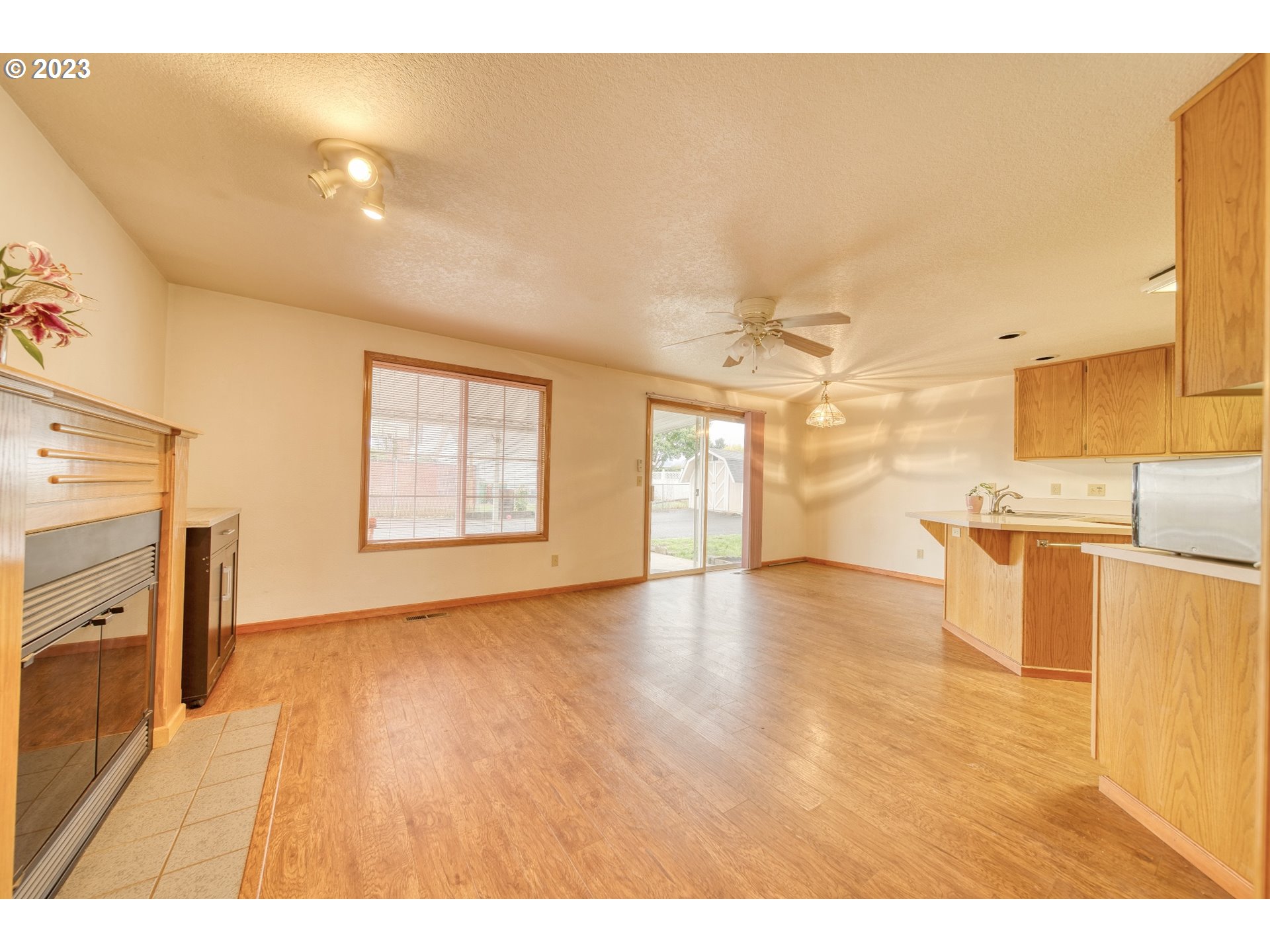 33912 Southeast Everett Way Scappoose, OR 97056 - Photo 7 of 32 a view of a kitchen with kitchen island a sink wooden floor and a large window