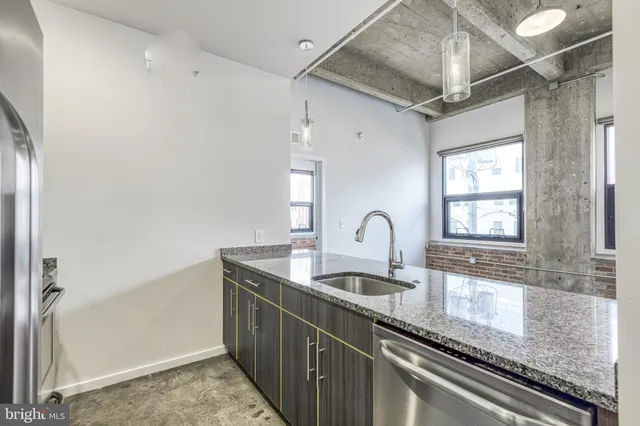 a kitchen with granite countertop a sink and cabinets