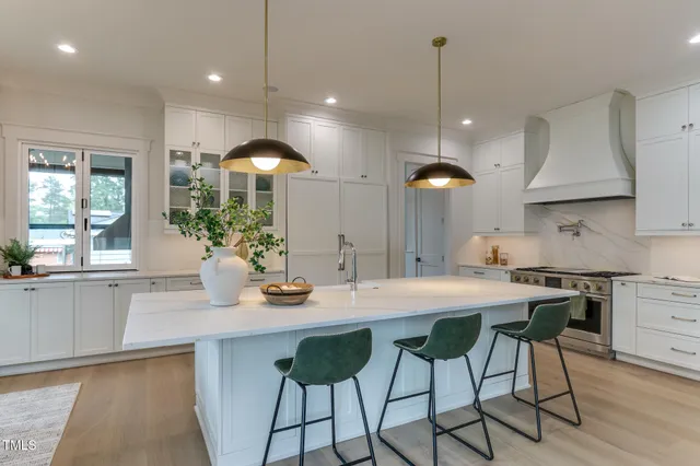 a kitchen with kitchen island a stove a table and chairs in it