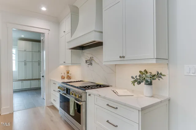 a kitchen with stainless steel appliances a white stove top oven and cabinets