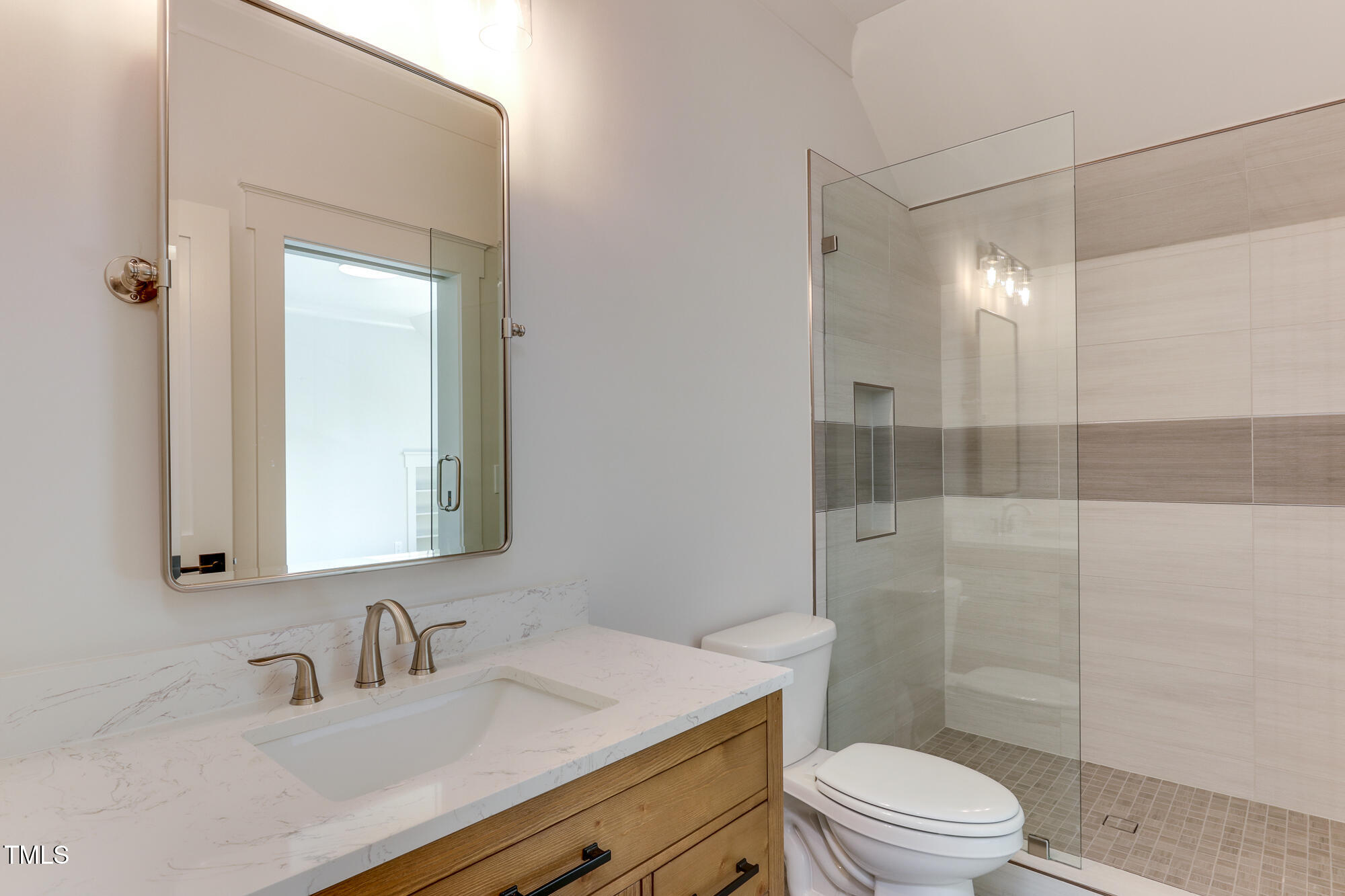 4921 Sweetbriar Drive Raleigh, NC 27609 - Photo 26 of 42 a bathroom with a sink toilet vanity and shower