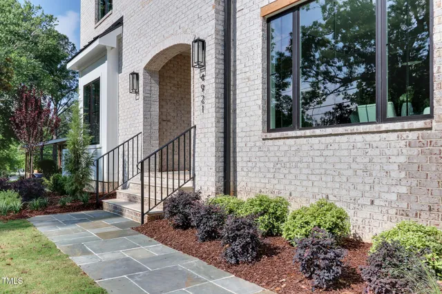 a view of a house with brick walls and flower plants