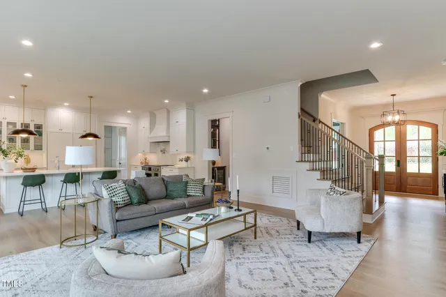 a living room with furniture and a dining table with wooden floor