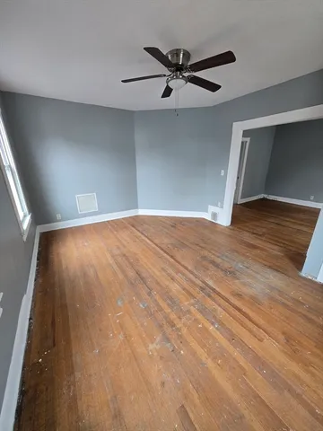 a view of an empty room with wooden floor