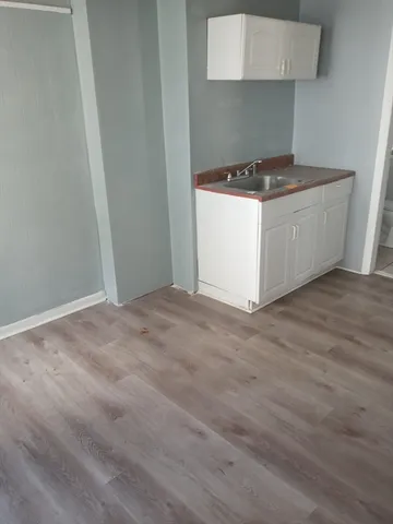 a kitchen with a stove and a wooden floor
