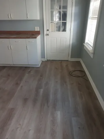 a view of a kitchen with wooden floor and cabinets