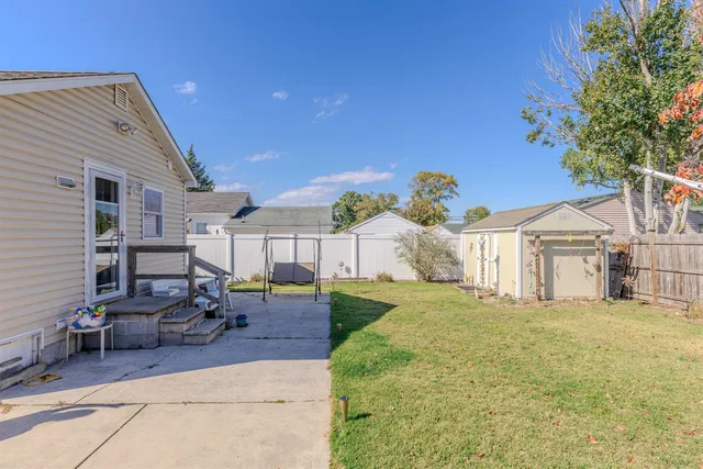 a backyard of a house with table and chairs