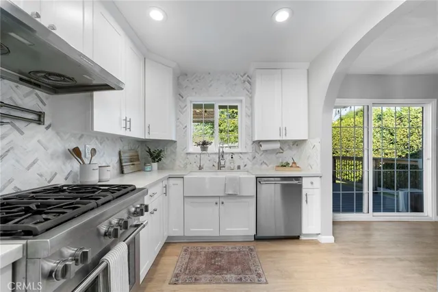 a kitchen with a stove a sink and a window