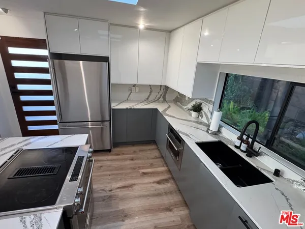 a kitchen with stainless steel appliances a sink stove and refrigerator