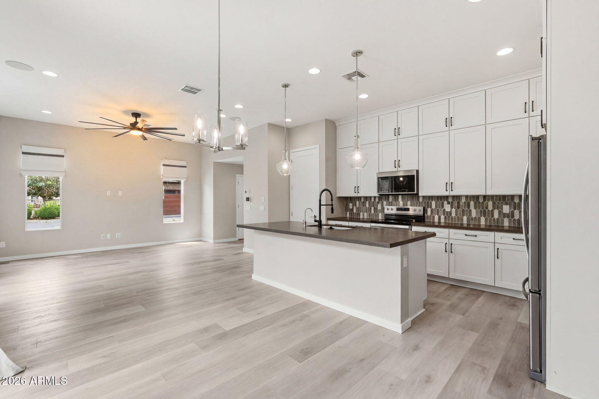901 South Smith Road, Unit 1038 Tempe, AZ 85281 - Photo 12 of 29 a open kitchen with granite countertop a stove top oven a sink dishwasher a dining table and chairs with wooden floor