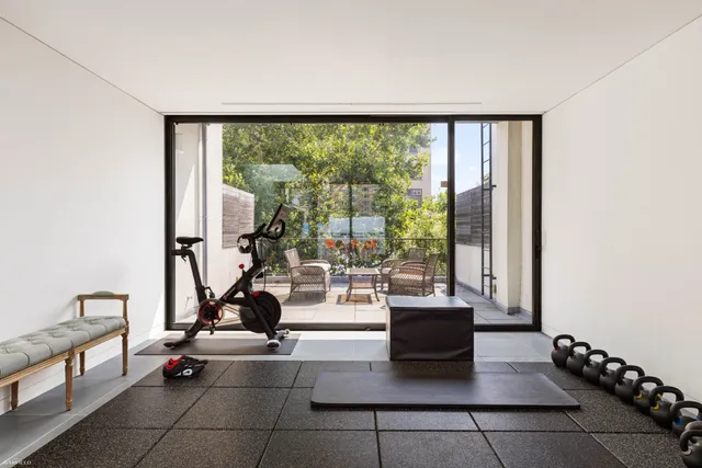 a living room with a large window and gym equipment