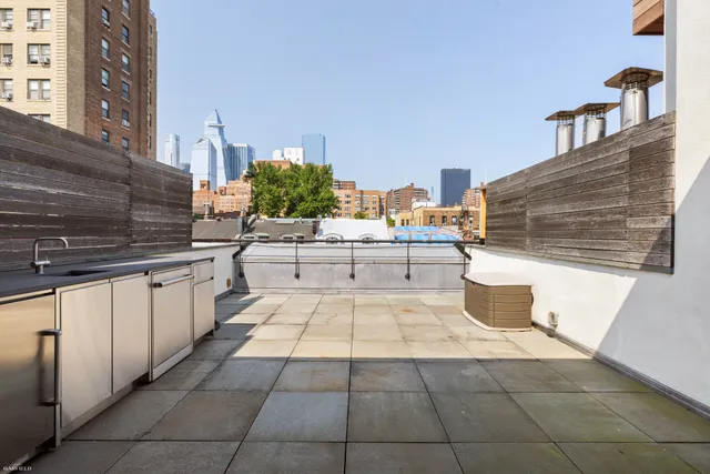 a large white kitchen with kitchen island granite countertop a sink and white cabinets
