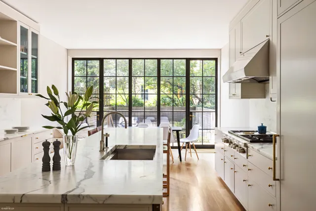 a living room with furniture large windows and wooden floor