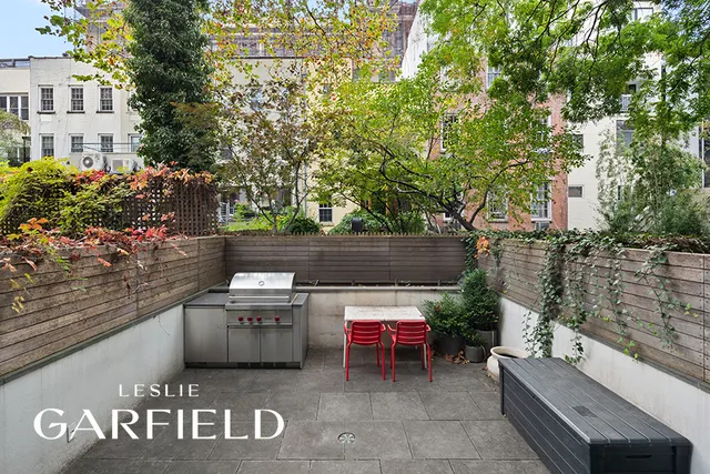 a view of a chairs and table in the back yard of the house