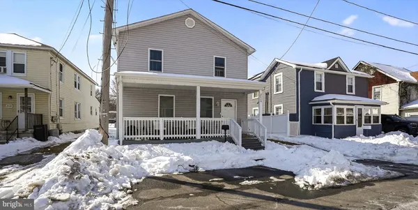 a front view of a house with a yard covered in snow