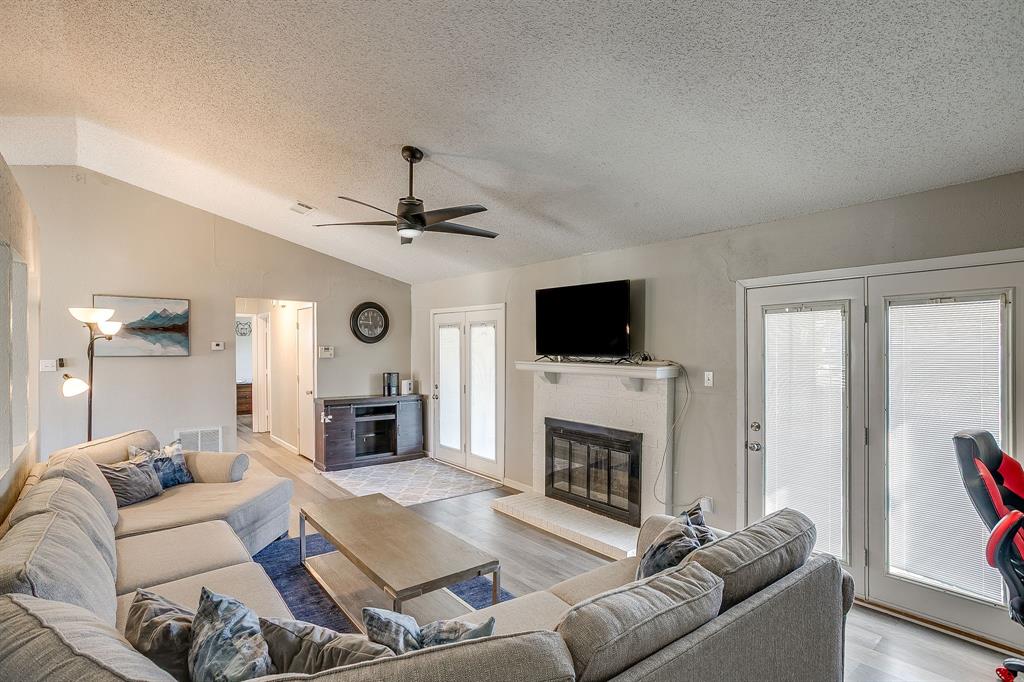7312 Strawberry Way Fort Worth, TX 76137 - Photo 12 of 40 a living room with furniture a fireplace and a flat screen tv