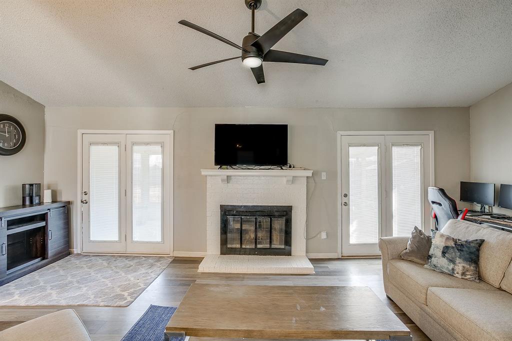 7312 Strawberry Way Fort Worth, TX 76137 - Photo 13 of 40 a living room with furniture a fireplace and a flat screen tv
