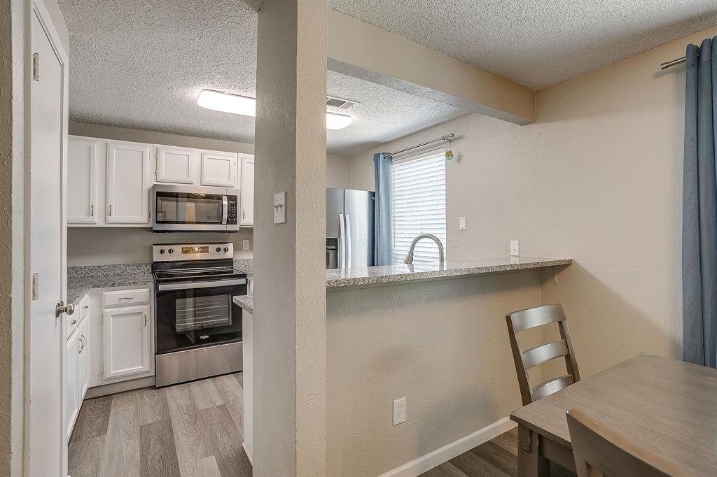 7312 Strawberry Way Fort Worth, TX 76137 - Photo 19 of 40 a kitchen with a refrigerator and a stove top oven