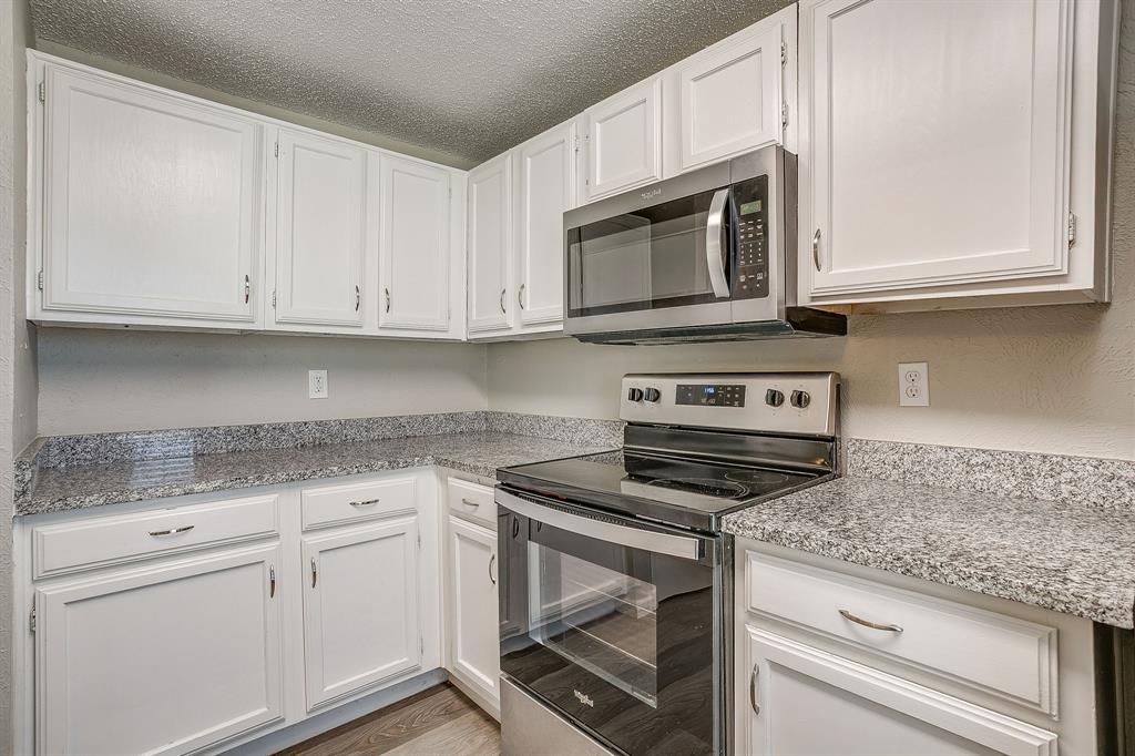 7312 Strawberry Way Fort Worth, TX 76137 - Photo 23 of 40 a kitchen with granite countertop white cabinets and a stove top oven