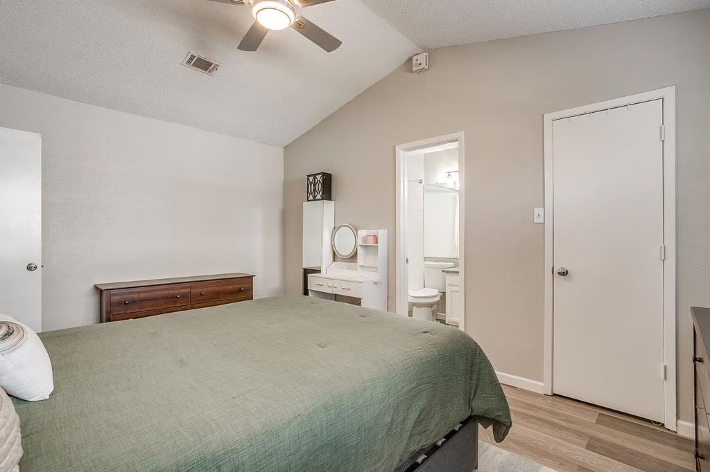 7312 Strawberry Way Fort Worth, TX 76137 - Photo 27 of 40 a bedroom with a bed and a chandelier