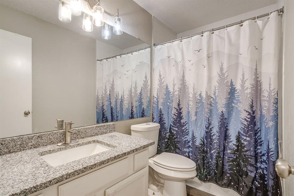 7312 Strawberry Way Fort Worth, TX 76137 - Photo 29 of 40 a bathroom with a granite countertop sink a toilet and a mirror