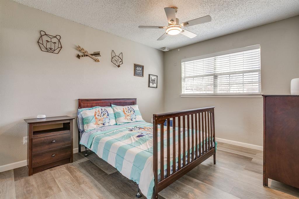 7312 Strawberry Way Fort Worth, TX 76137 - Photo 34 of 40 a bedroom with a bed and a chandelier