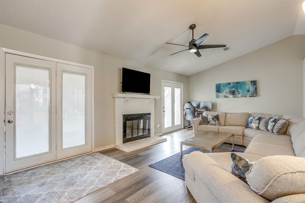 7312 Strawberry Way Fort Worth, TX 76137 - Photo 7 of 40 a living room with furniture a fireplace and a flat screen tv