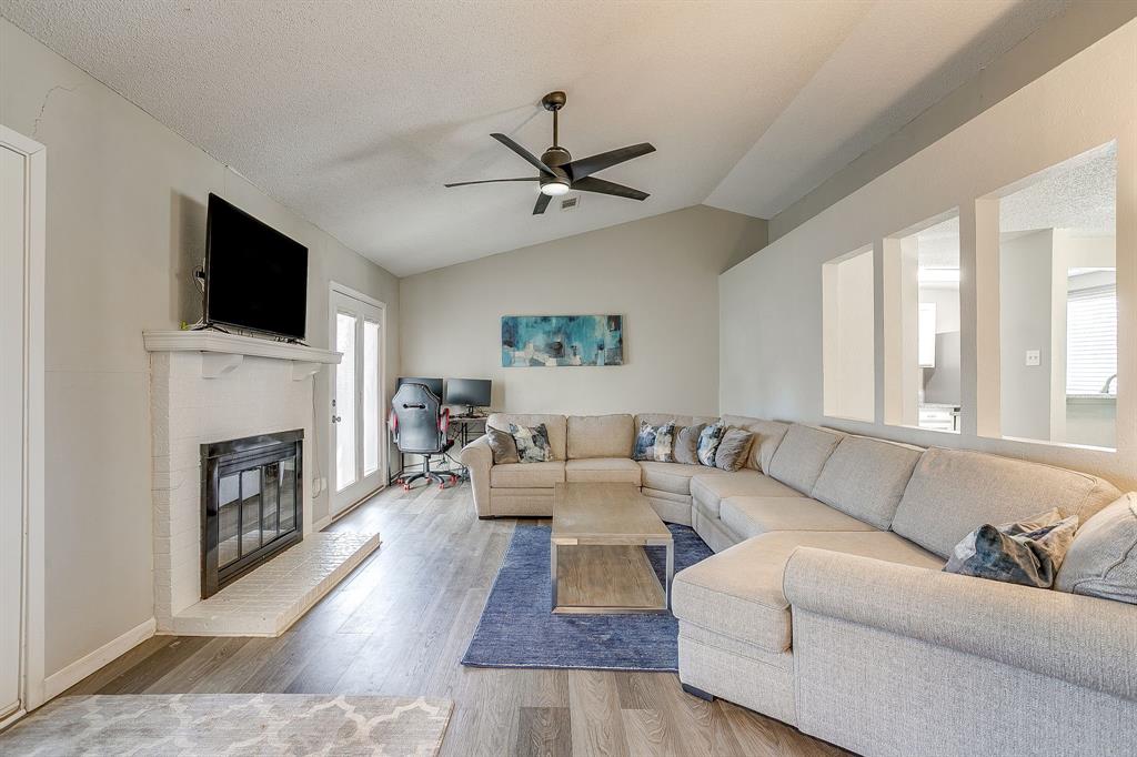 7312 Strawberry Way Fort Worth, TX 76137 - Photo 8 of 40 a living room with furniture a fireplace and a flat screen tv