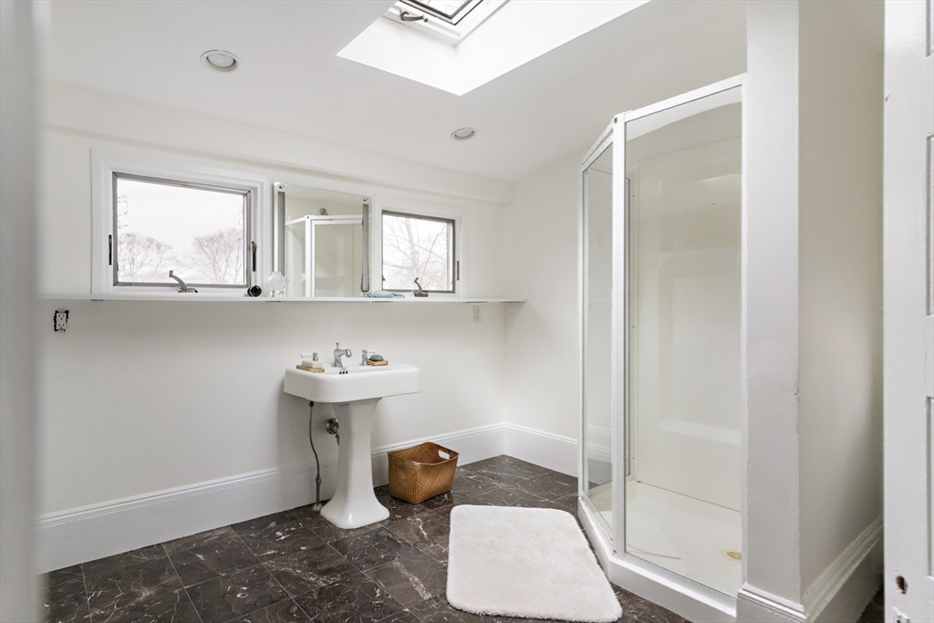 52 Hillside Road Watertown, MA 02472 - Photo 23 of 27 a bathroom with a sink a mirror and window