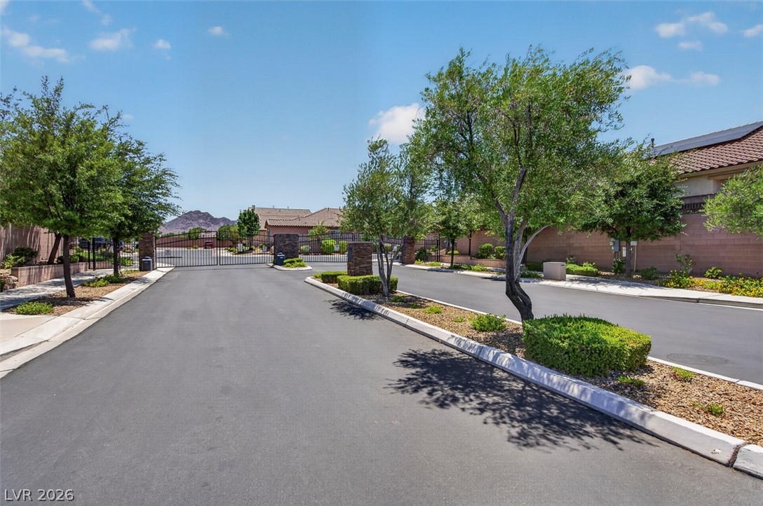1824 Redland Ridge Street Henderson, NV 89002 - Photo 67 of 69 Secure community entrance with an elegant wrought iron gate and lush, maintained landscaping.