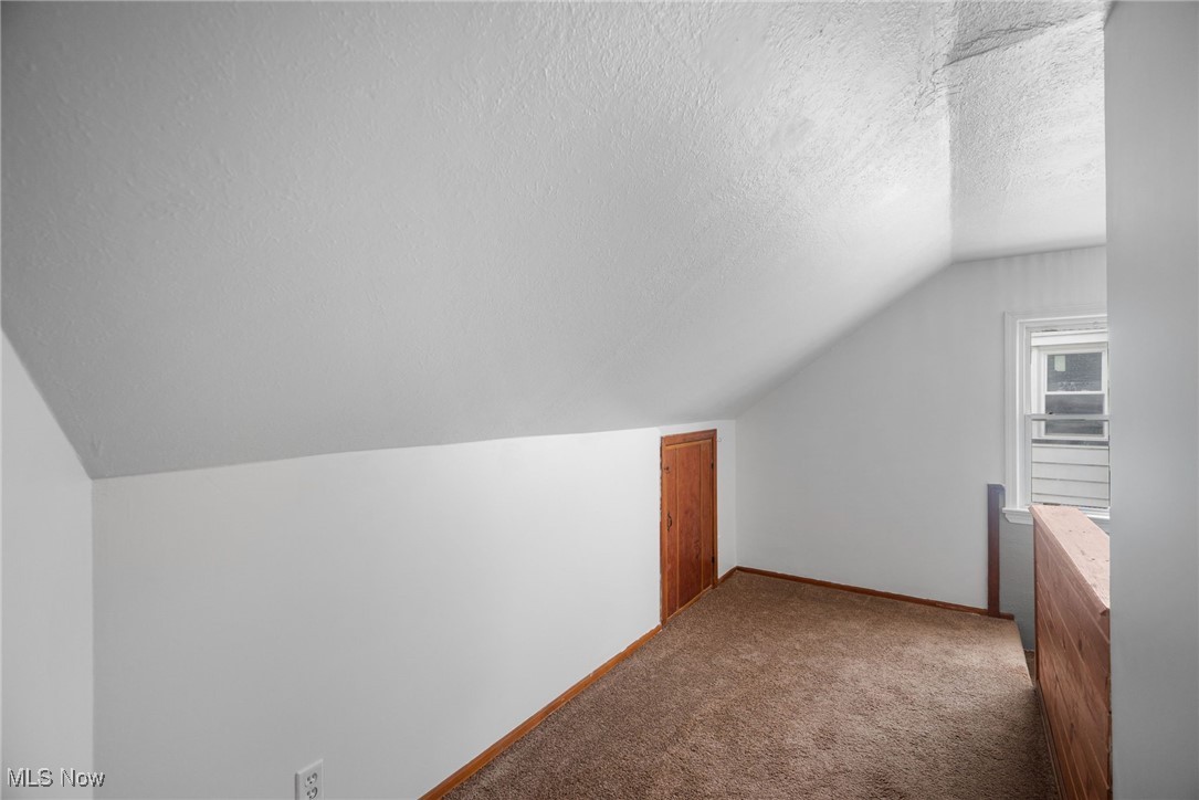 5618 Ackley Road Cleveland, OH 44129 - Photo 28 of 38 Bonus room with a textured ceiling, carpet, and lofted ceiling
