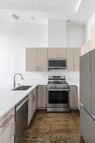a view of a kitchen with wooden floor and a sink