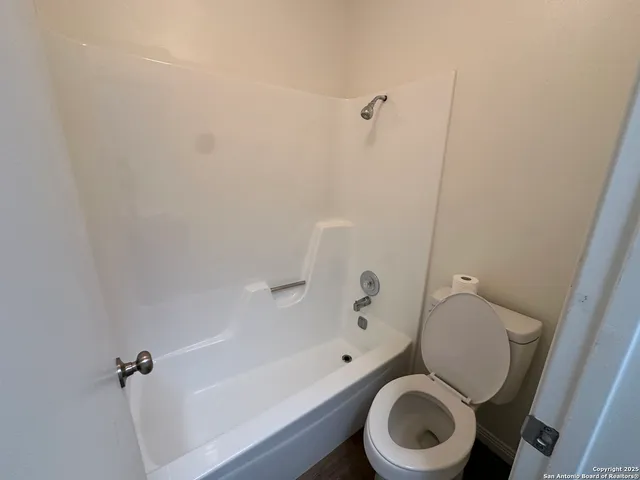 a white toilet sitting next to a bath tub