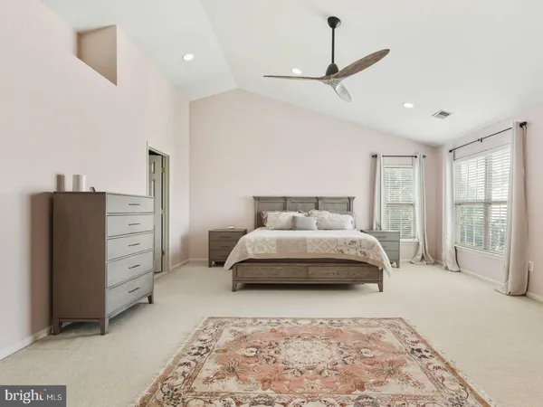 a spacious bedroom with a bed and a dresser