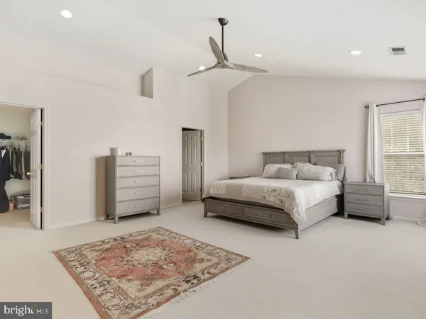 a bedroom with a bed dresser and a rug