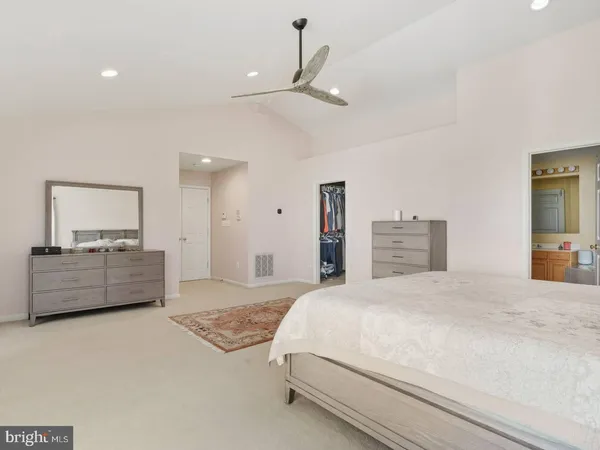 a spacious bedroom with a bed and a large mirror